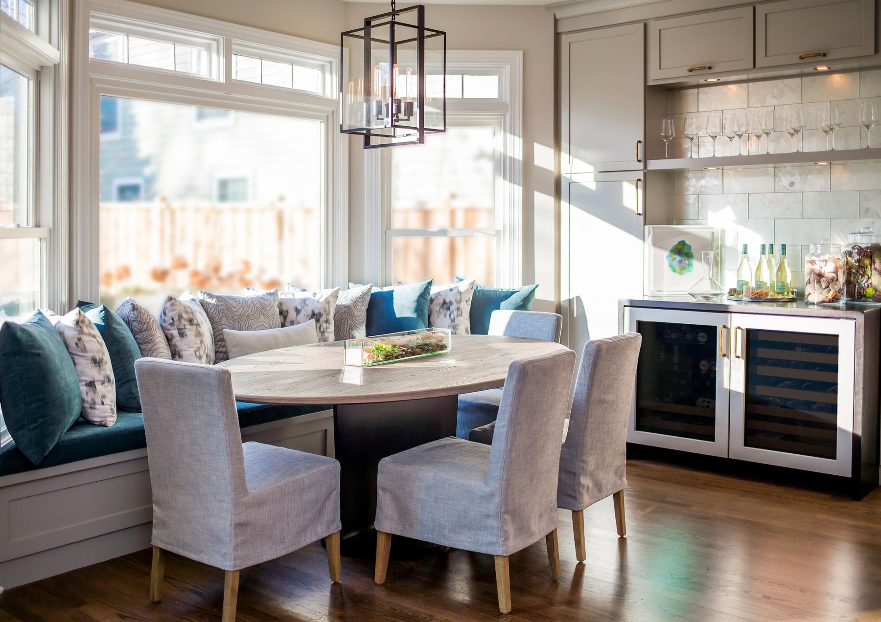 Breakfast nook with banquette, oval table and wine bar