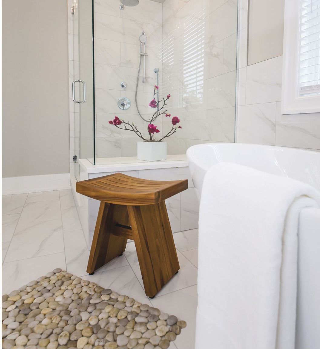 Marble bath with teak stool and pebble mat