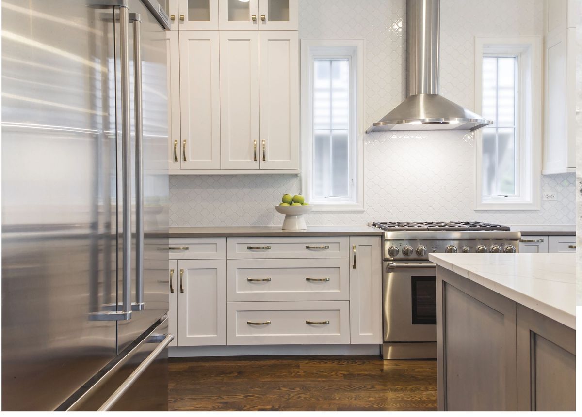 White kitchen with stainless range and grey island