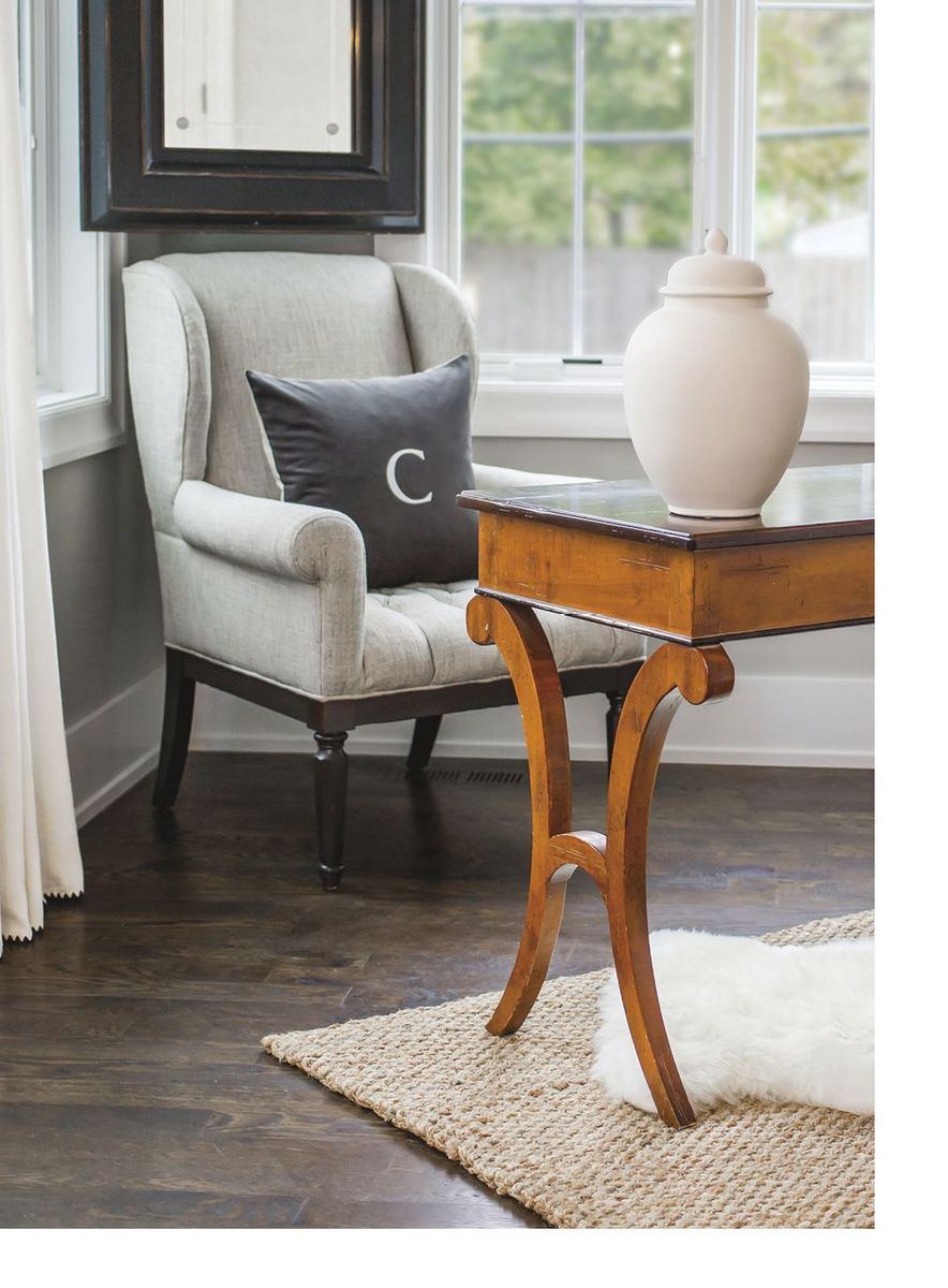 Wing chair and antique table by a window