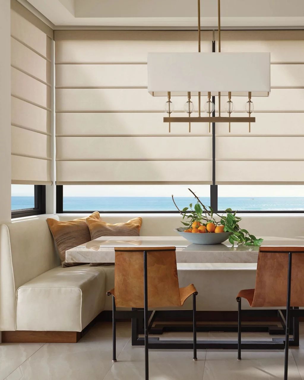 Breakfast nook with layered woven shades and sheer drapery